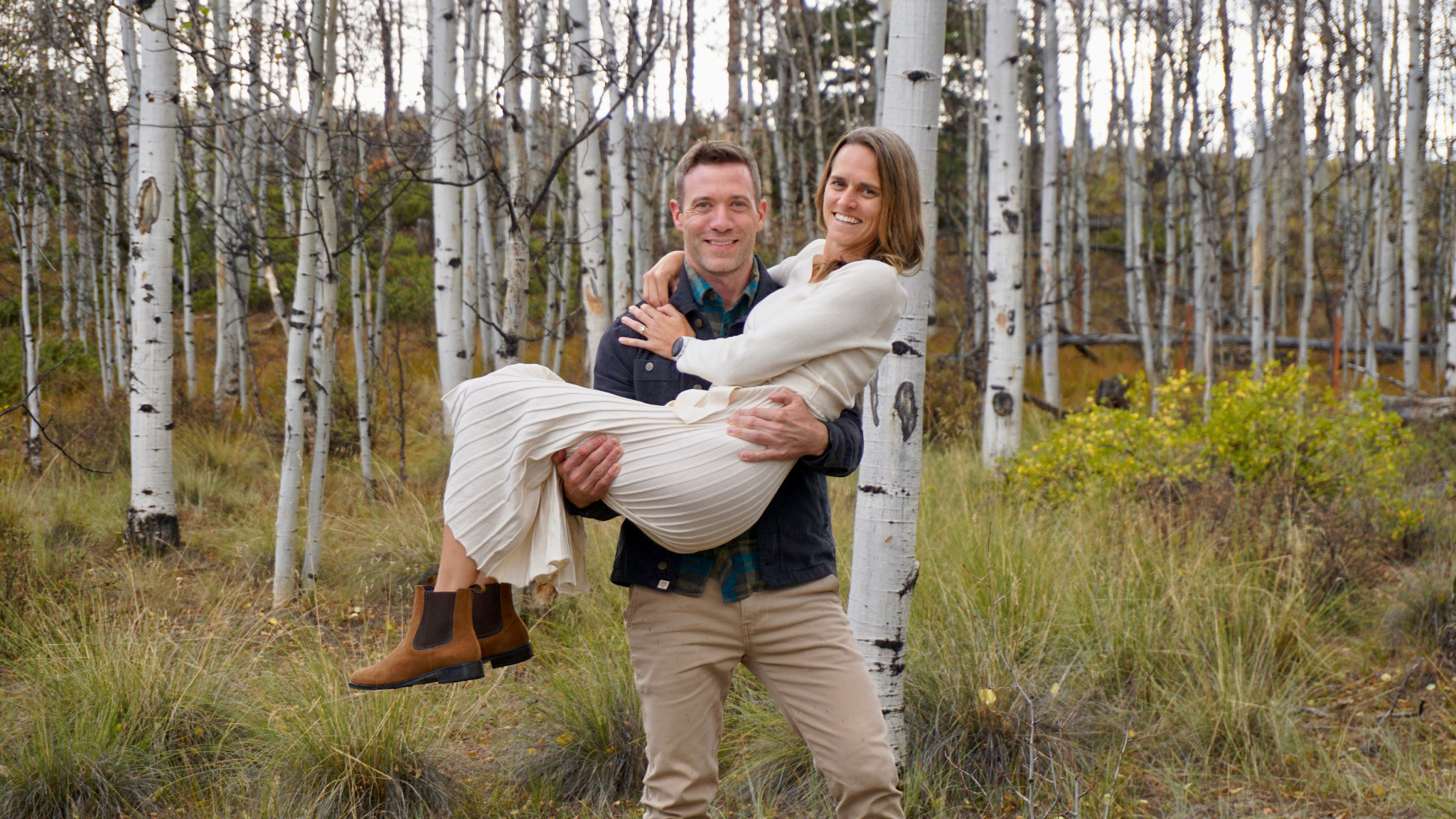 Jared holding Bryn among aspen trees in Colorado
